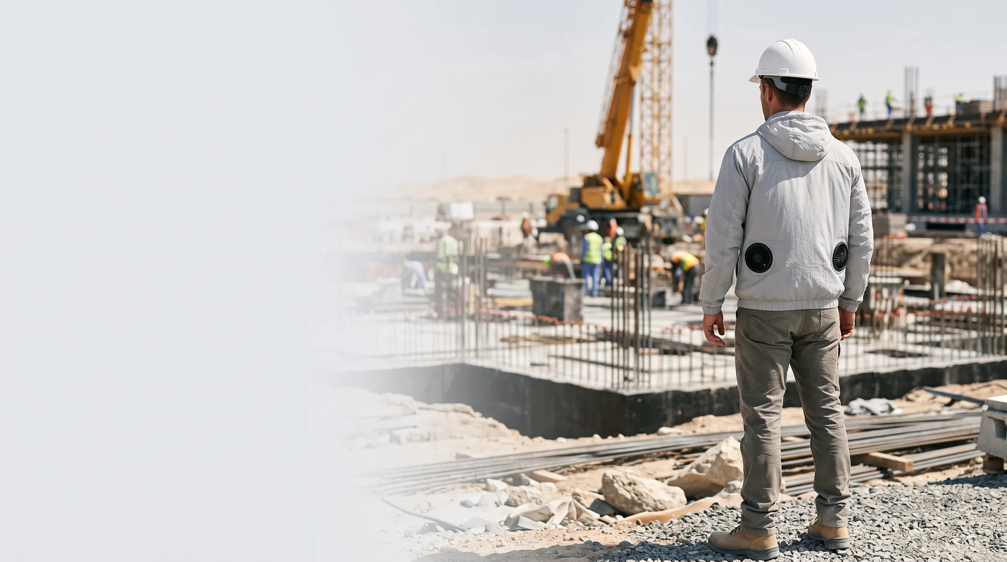 Construction worker wearing a lightweight hooded cooling jacket with twin lower-back fans at a UAE project site
